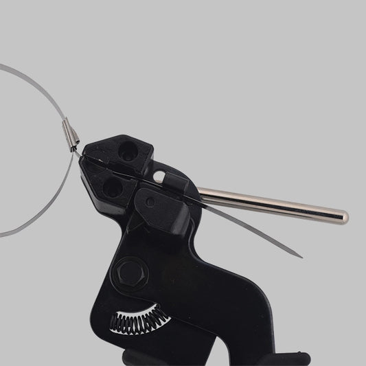 Black hand-held JCTCTTS-HD stainless steel cable tie tensioning gun pulling tight a silver stainless steel cable tie