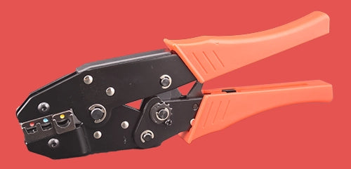 Professional insulated terminal crimper with black metal body and orange grip handles, featuring multiple crimping die sizes for red, blue, and yellow insulated terminals, displayed on coral background
